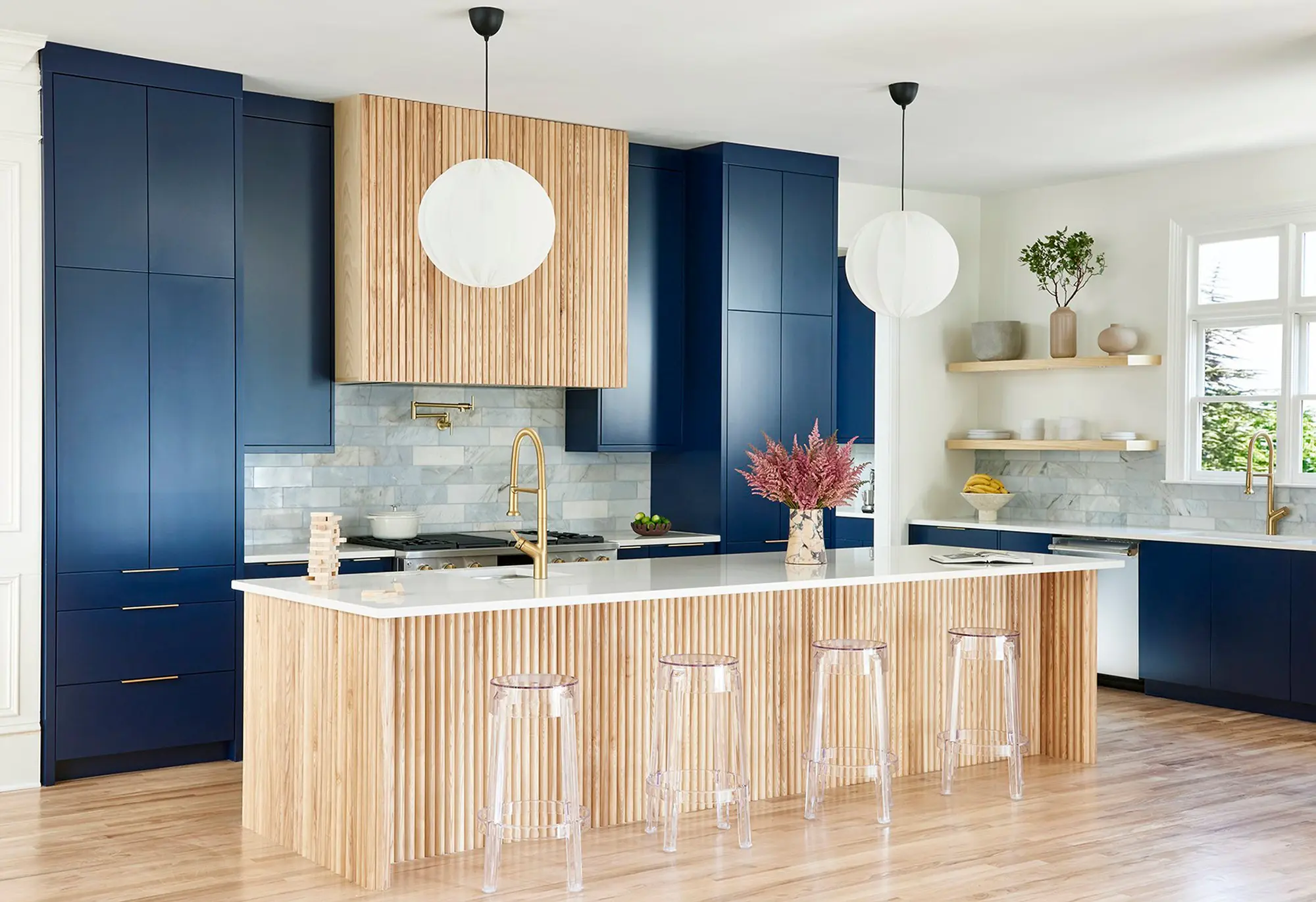 Modern kitchen with navy cabinets and Surfacing Solution’s solid ash tambour paneling, profile 493.